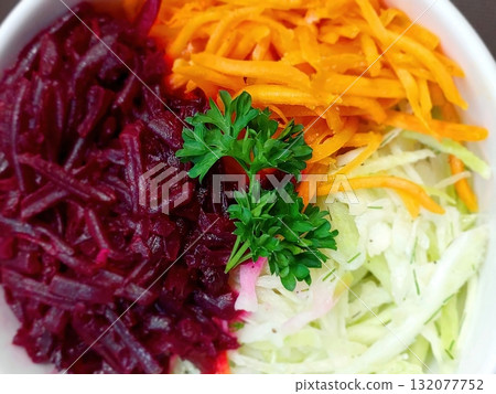 Freshly Prepared Salad With Parsley, Red Beet, Carrot, and Cabbage in a White Bowl 132077752