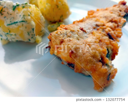 Smeared Fish Served With Seasoned Potatoes on a White Plate 132077754