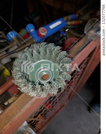 Wire Brush for Grinder Ready for Metal Cleaning in Workshop With Various Tools Nearby 132077766