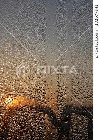 water droplets from condensation on the window at sunset, wet glass with lots of water droplets on the background of an orange sky out of focus at sunset water droplets from condensation on the window at sunset, wet glass with lots of water droplets on the background of an orange sky out of focus at sunset 132077841