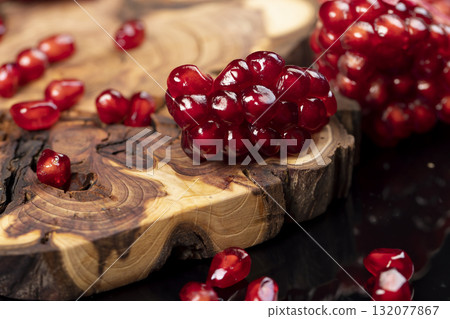red ripe peeled pomegranate with large juicy grains, sweet pomegranate with juicy red grains on the table, fruit details red ripe peeled pomegranate with large juicy grains, sweet pomegranate with juicy red grains on the table, fruit details 132077867