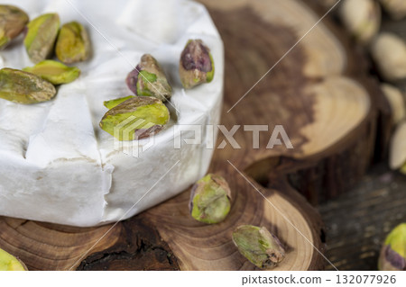 peeled pistachios are green in color along with whole cheese in white mold, delicious white soft cheese in mold and a large number of salted pistachios with and without cracked shells peeled pistachios are green in color along with whole cheese in white mold, delicious white soft cheese in mold and a large number of salted pistachios with and without cracked shells 132077926