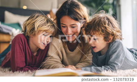 Joyful Family Reading: A Warm, Close-Up Moment of a Mother and Her Two Young Sons Sharing a Storybook While Relaxing on a Cozy Rug at Home Joyful Family Reading: A Warm, Close-Up Moment of a Mother and Her Two Young Sons Sharing a Storybook While Relaxing on a Cozy Rug at Home 132078319