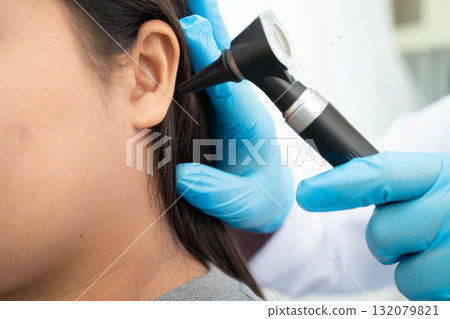 Otolaryngologist or ENT physician doctor examining senior patient ear with otoscope, hearing loss problem. Otolaryngologist or ENT physician doctor examining senior patient ear with otoscope, hearing loss problem. 132079821