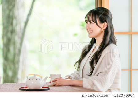 Ryokan, young Asian woman drinking tea in a Japanese-style room in a Japanese house Ryokan, young Asian woman drinking tea in a Japanese-style room in a Japanese house 132079904