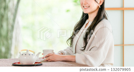Ryokan, young Asian woman drinking tea in a Japanese-style room in a Japanese house 132079905
