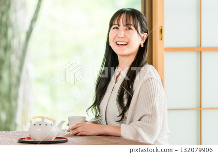 Ryokan, young Asian woman drinking tea in a Japanese-style room in a Japanese house 132079906