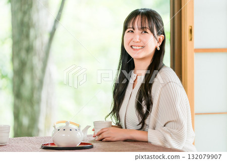 日式旅館，身穿浴衣的亞洲年輕女子在日式房屋的日式房間喝茶 132079907