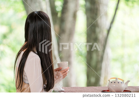 Ryokan, young Asian woman drinking tea in a Japanese-style room in a Japanese house 132080211
