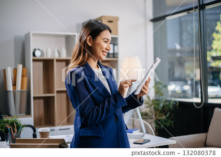 Confident business expert attractive smiling young woman holding digital tablet on desk Confident business expert attractive smiling young woman holding digital tablet on desk 132080378