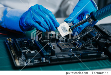 The technician is putting the CPU on the socket of the computer motherboard. electronic engineering electronic repair, 132080533