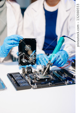 The technician is putting the CPU on the socket of the computer motherboard. electronic engineering electronic repair, electronics measuring The technician is putting the CPU on the socket of the computer motherboard. electronic engineering electronic repair, electronics measuring 132080553