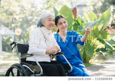 Asian young caregiver nurse support senior older male walking outdoors. Specialis doctor help and take care of elderly mature. Asian young caregiver nurse support senior older male walking outdoors. Specialis doctor help and take care of elderly mature. 132080640