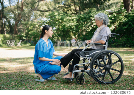 Asian physiotherapist helping elderly woman patient stretching arm during exercise correct with dumbbell in hand during training hand with patient Back problems in the garden. Asian physiotherapist helping elderly woman patient stretching arm during exercise correct with dumbbell in hand during training hand with patient Back problems in the garden. 132080675