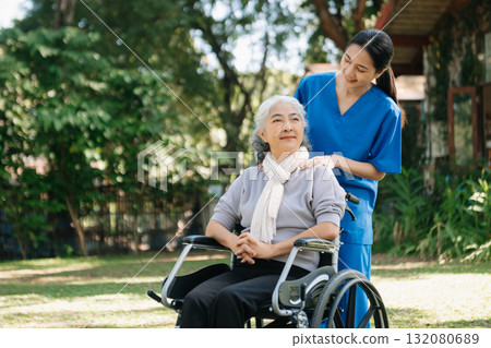 Asian physiotherapist helping elderly woman patient stretching arm during exercise correct with dumbbell in hand during training hand with patient Back problems in the garden. Asian physiotherapist helping elderly woman patient stretching arm during exercise correct with dumbbell in hand during training hand with patient Back problems in the garden. 132080689
