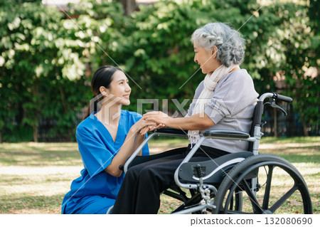 Asian physiotherapist helping elderly woman patient stretching arm during exercise correct with dumbbell in hand during training hand with patient Back problems in the garden. 132080690