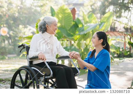 Elderly asian senior woman on wheelchair with Asian careful caregiver. Nursing home hospital Elderly asian senior woman on wheelchair with Asian careful caregiver. Nursing home hospital 132080710