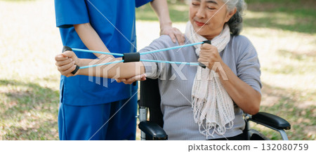 Asian physiotherapist helping elderly woman patient stretching arm during exercise correct with dumbbell in hand during training hand with patient Back problems in the garden. Asian physiotherapist helping elderly woman patient stretching arm during exercise correct with dumbbell in hand during training hand with patient Back problems in the garden. 132080759