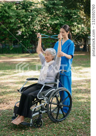 Asian physiotherapist helping elderly woman patient stretching arm during exercise correct with dumbbell in hand during training hand with patient Back problems in the garden. Asian physiotherapist helping elderly woman patient stretching arm during exercise correct with dumbbell in hand during training hand with patient Back problems in the garden. 132080760
