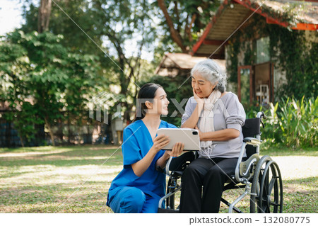 Asian old woman sitting on a wheelchair outdoors in the park Have pain in the arms, wrists and body Asian old woman sitting on a wheelchair outdoors in the park Have pain in the arms, wrists and body 132080775