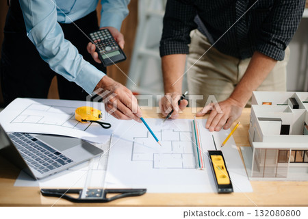 Two colleagues discussing data working and tablet, laptop with architectural project at construction site 132080800