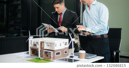 Meeting of architects, designers, and developers creating innovative, sustainable housing projects using building models and digital tools. 132080815