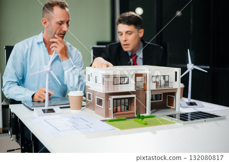 Meeting of architects, designers, and developers creating innovative, sustainable housing projects using building models and digital tools. 132080817