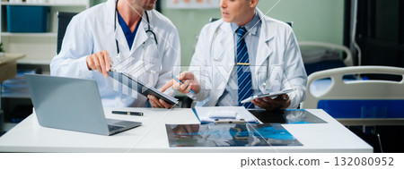 Diverse team of doctors and specialists brainstorming with digital tools, discussing test results and planning in hospital Diverse team of doctors and specialists brainstorming with digital tools, discussing test results and planning in hospital 132080952