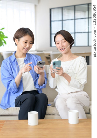 Japanese women sitting on the sofa and having a conversation Japanese women sitting on the sofa and having a conversation 132080954