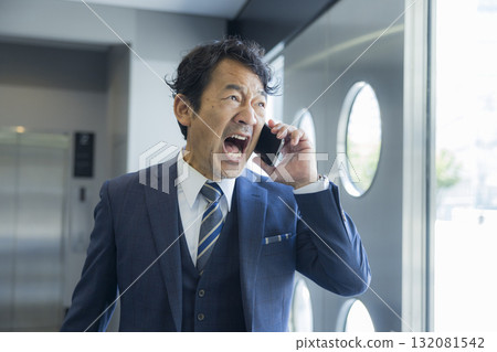 A businessman surprised to see smartphone A businessman surprised to see smartphone 132081542