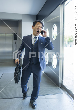 A businessman surprised to see smartphone 132081543