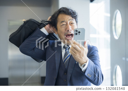一名商人驚訝地看到智能手機 132081548