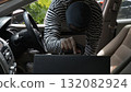 Masked thief stealing a briefcase from inside a car, symbolizing crime, theft, and loss. Concept of security awareness, vehicle safety, and prevention of property theft in daily urban environments 132082924