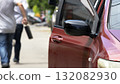 open car door with a man walking away holding a briefcase after a robbery, concept of crime, danger, theft, and security awareness. Represents the aftermath of a carjacking or street crime situation 132082930