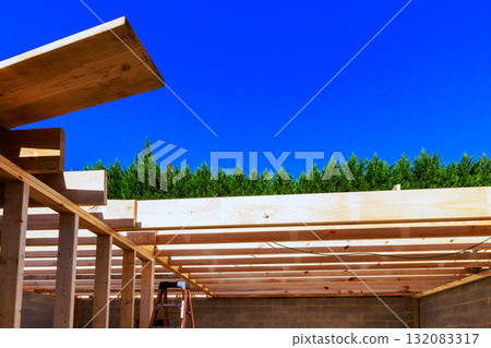 Workers install wooden beams at construction site with roof rafters structure beams Workers install wooden beams at construction site with roof rafters structure beams 132083317