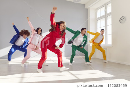 Happy Team Dancing In Colorful Suits In Empty Room 132083469