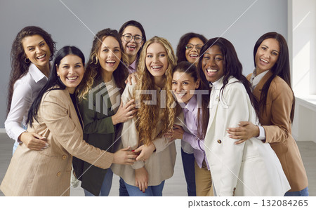 Happy cheerfull young diverse women friends or coworkers looking at camera on grey background. 132084265