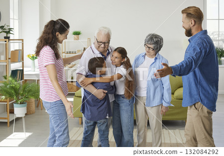 Joyful little grandson and granddaughter meeting and hugging their happy grandparents 132084292