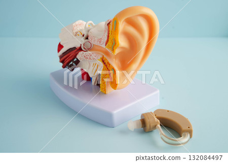 Otoscope with ear model for otolaryngologist or ENT physician doctor examining senior patient ear, hearing loss problem. 132084497