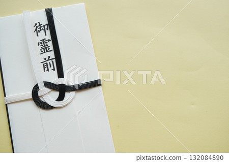 A photo of a condolence envelope with the words "Goreizen" written on it, and a black and white Mizuhiki envelope used at funerals A photo of a condolence envelope with the words "Goreizen" written on it, and a black and white Mizuhiki envelope used at funerals 132084890