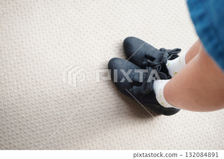 Photo of a child's feet wearing shoes with black ribbons Photo of a child's feet wearing shoes with black ribbons 132084891