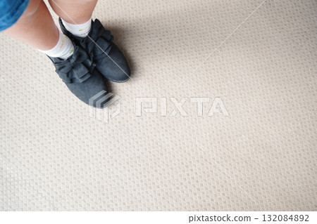 Photo of a child's feet wearing shoes with black ribbons Photo of a child's feet wearing shoes with black ribbons 132084892