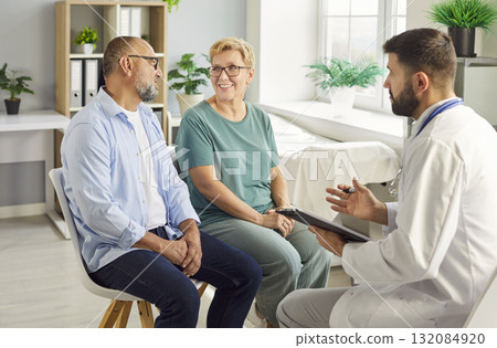 Doctor consulting senior couple in a bright clinic during appointment and support 132084920