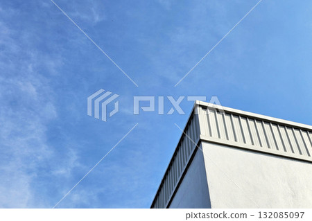 Modern building with standing seam metal cladding under a clear blue sky. Modern building with standing seam metal cladding under a clear blue sky. 132085097