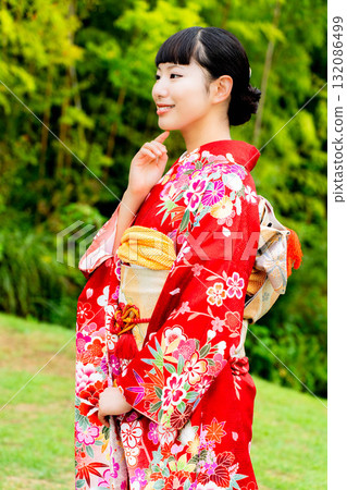 A Japanese woman wearing a furisode kimono standing in a bamboo forest A Japanese woman wearing a furisode kimono standing in a bamboo forest 132086499