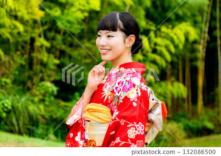 A Japanese woman wearing a furisode kimono standing in a bamboo forest A Japanese woman wearing a furisode kimono standing in a bamboo forest 132086500