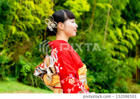 A Japanese woman wearing a furisode kimono standing in a bamboo forest A Japanese woman wearing a furisode kimono standing in a bamboo forest 132086501