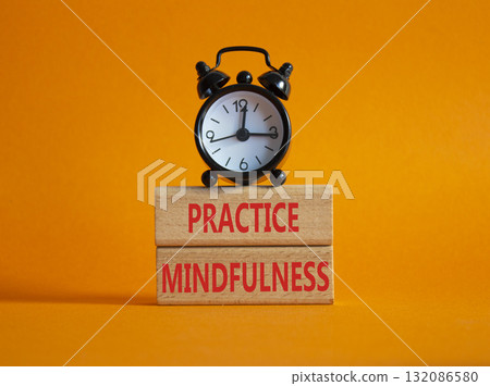Practice Mindfulness symbol. Wooden blocks with words Practice Mindfulness. Beautiful orange background with alarm clock. Medical and Psychology and Practice Mindfulness concept. Copy space. 132086580