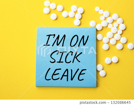 Sick leave symbol. Concept word I am on sick leave on blue note. Beautiful yellow background with pills. Medicine and I am on sick leave concept. Copy space Sick leave symbol. Concept word I am on sick leave on blue note. Beautiful yellow background with pills. Medicine and I am on sick leave concept. Copy space 132086645