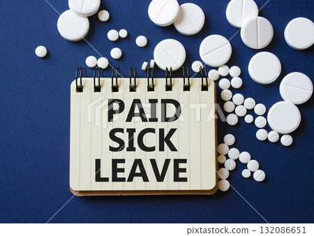 Paid Sick Leave symbol. Concept words Paid Sick Leave on notebook. Beautiful deep blue background with pills. Healthcare and Paid Sick Leave concept. Copy space. 132086651